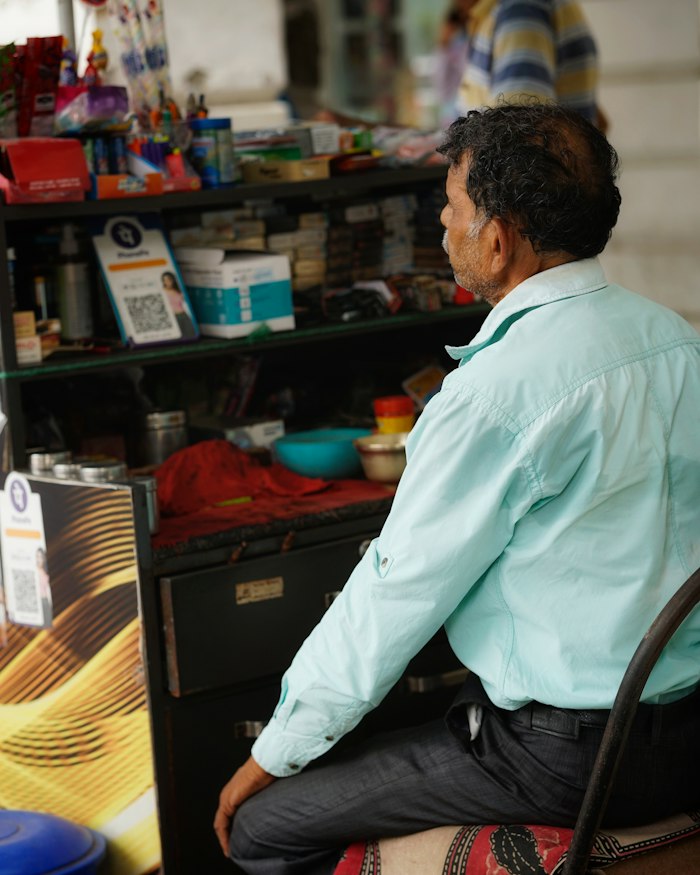 Shop owner seated outside his store