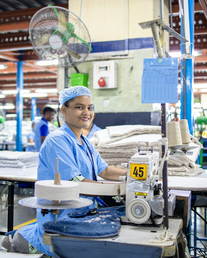 Textile worker sewing fabric in a factory